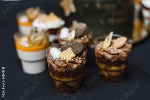 chocolate cake in a glass with cookies on a black background