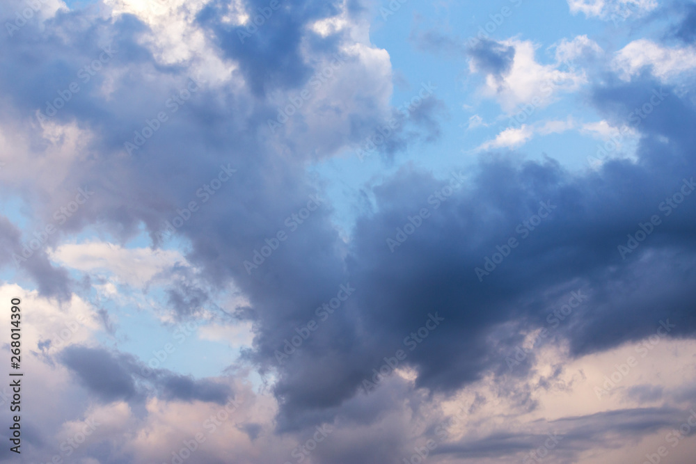 Epic dramatic storm cumulus fluffy clouds in sunlight against blue sky background, heaven texture