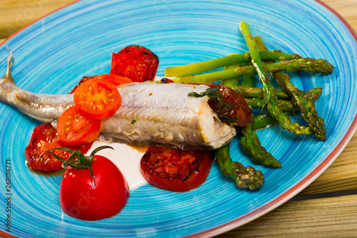 Baked fish poutassou with dried tomatoes, asparagus and creamy-garlic sauce photo