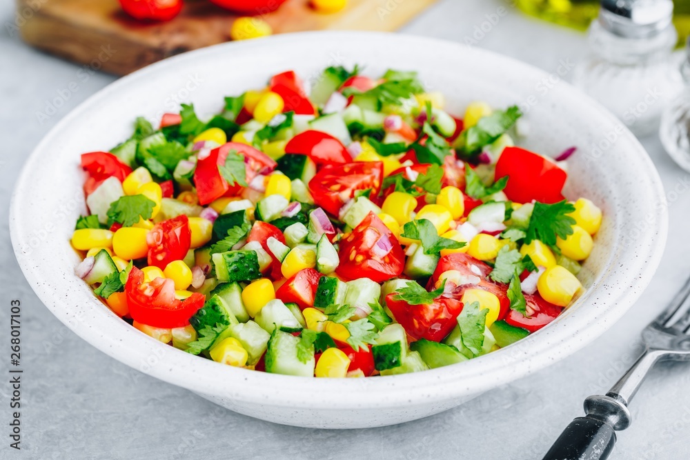 Fresh summer corn salad bowl with tomatoes, cucumbers, red onions and parsley. - obrazy, fototapety, plakaty 