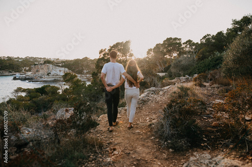 man and woman standing on cliff during daytime photo