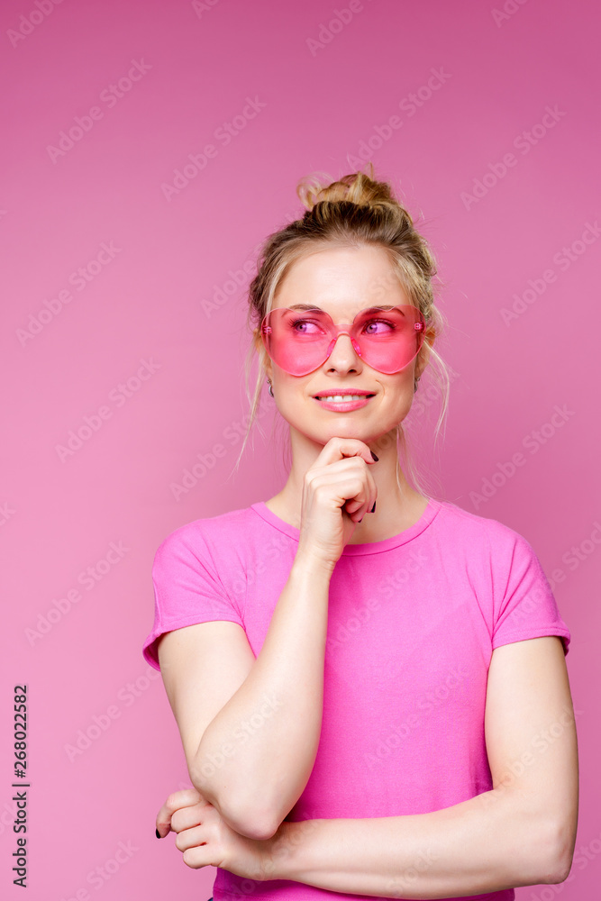 Φωτογραφία Photo of pensive blonde woman in pink t-shirt with raised hands