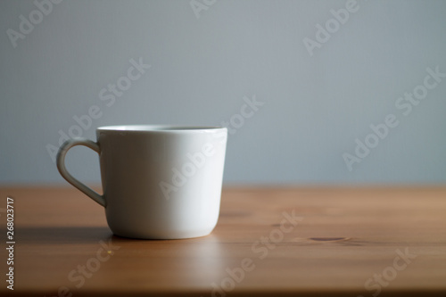 white coffee mug on wooden table and light background
