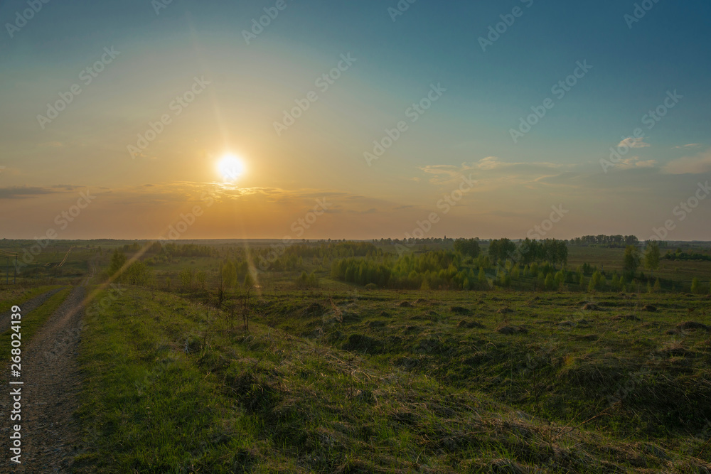 A bright white sun disc in an orange halo at sunset.