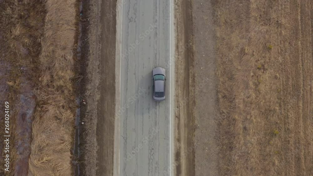 Aerial view the car goes on the road in the village. Aerial view the car goes on the road in the village.