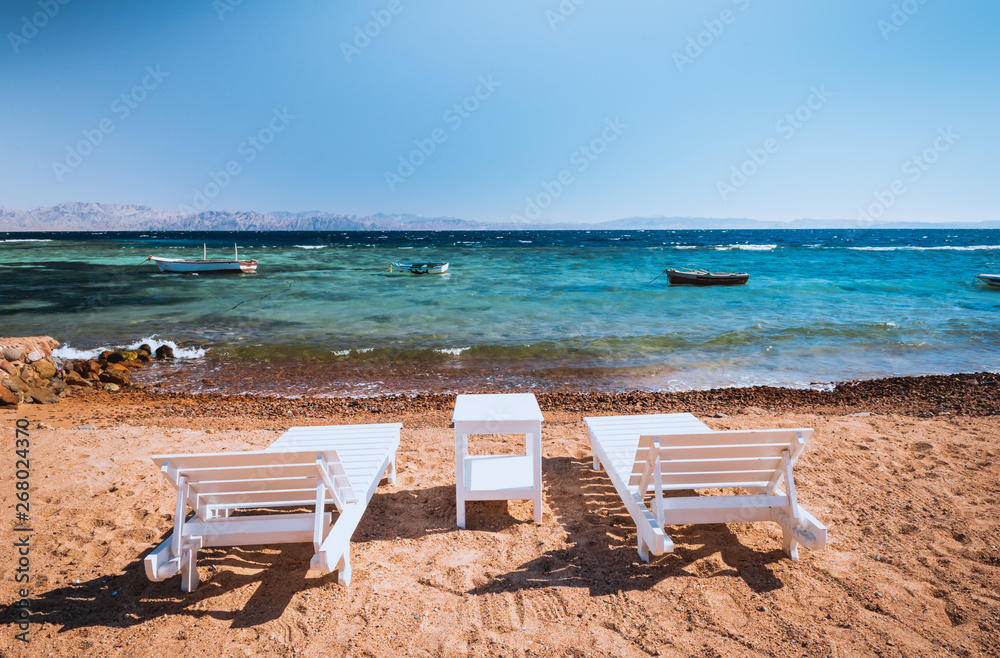 lounge chairs on beautiful tropical beach at Egypt, Dahab