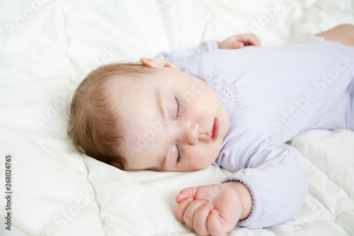 newborn baby sleeps sweetly on the bright bed