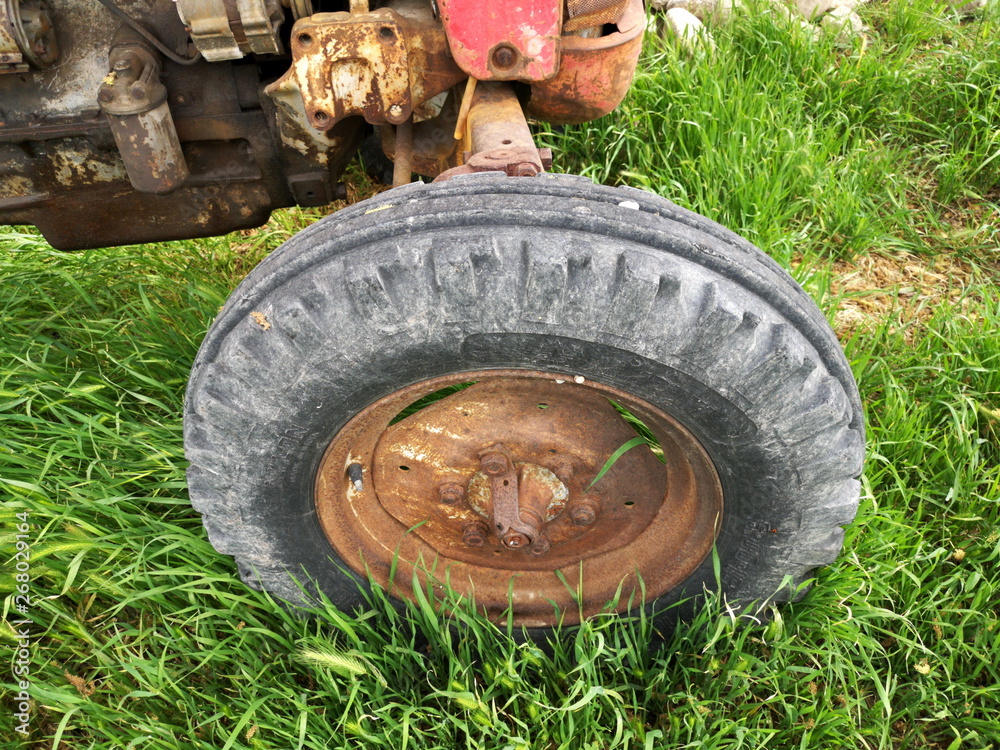 Φωτογραφία Rad und Reifen eines ausrangierten alten Traktor in Rot für die Landwirtschaft m