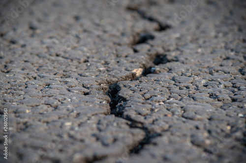 terrible crack in the road pavement, close up blurry background