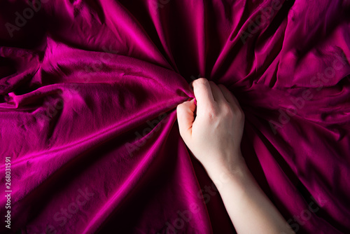 Photos Woman hand on the silk bedding, sex and orgasm concept