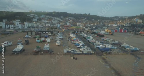 Tracking aerial shot of fishing boats moored on beach in traditional English seaside town of Hastings United Kingdom photo