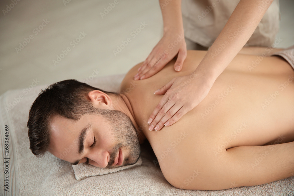 Handsome man receiving back massage in spa salon Handsome man receiving back massage in spa salon