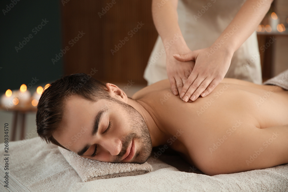Handsome man receiving back massage in spa salon Handsome man receiving back massage in spa salon