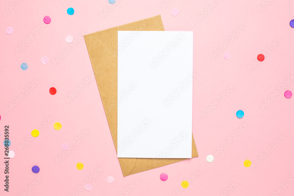 Greeting card and color confetti on pink table with space for text. Composition for birthday, mother day or wedding Greeting card and color confetti on pink table with space for text. Composition for birthday, mother day or wedding