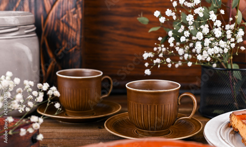 Cups for tea in vintage style with elements of decor. Wooden background and dishes.