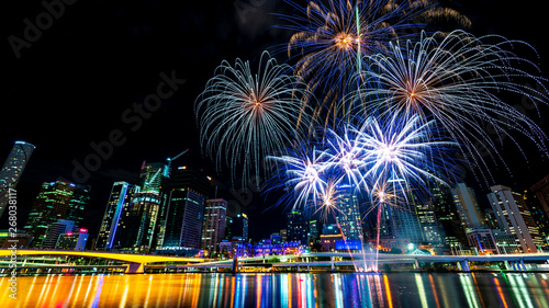 Wide angle nightscape fireworks in front of colour brisbane city