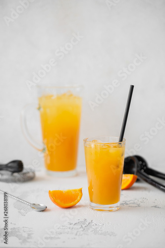Refreshing orange lemonade. Poured into a glass and carafe