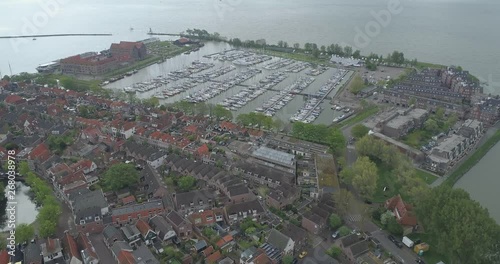 Aerial flying towards moored boats in the martina port area of traditional historic Dutch town of Hoorn in North Holland Netherlands Nederland past old houses photo