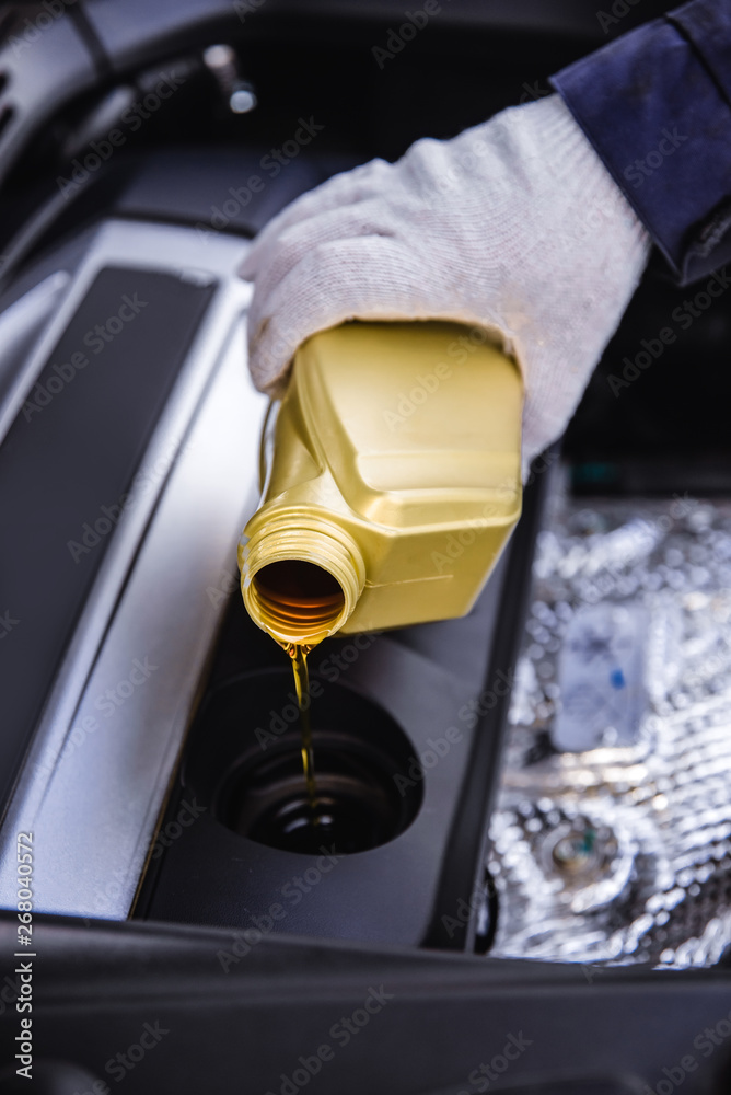 pouring engine oil into a car engine