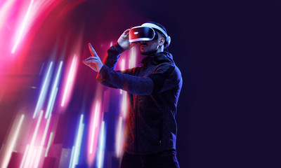 Model young man with beard in glasses of virtual reality. Augmented reality, science, future technology, people concept. VR. Futuristic 3d glasses with virtual projection. Neon light.