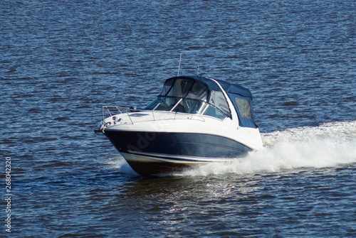 Motor boat, white trail on the water.