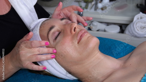 Caucasian woman enjoys a relaxing facial massage at a spa © Simone