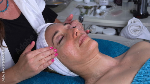 Caucasian woman enjoys a relaxing facial massage at a spa