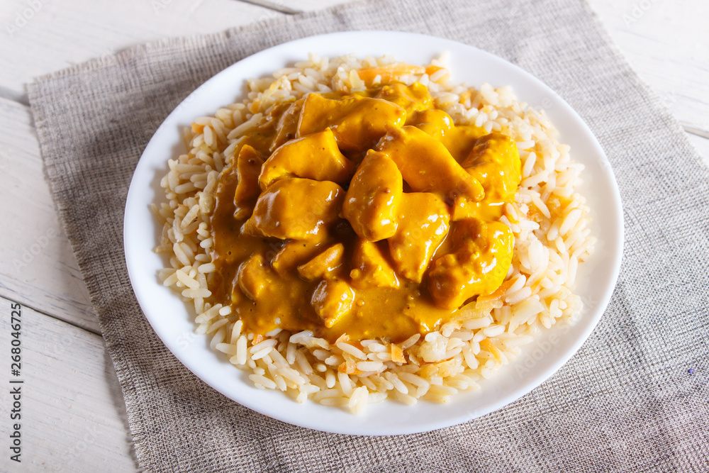 Rice with chicken curry sauce with cashew on white wooden background. Rice with chicken curry sauce with cashew on white wooden background.