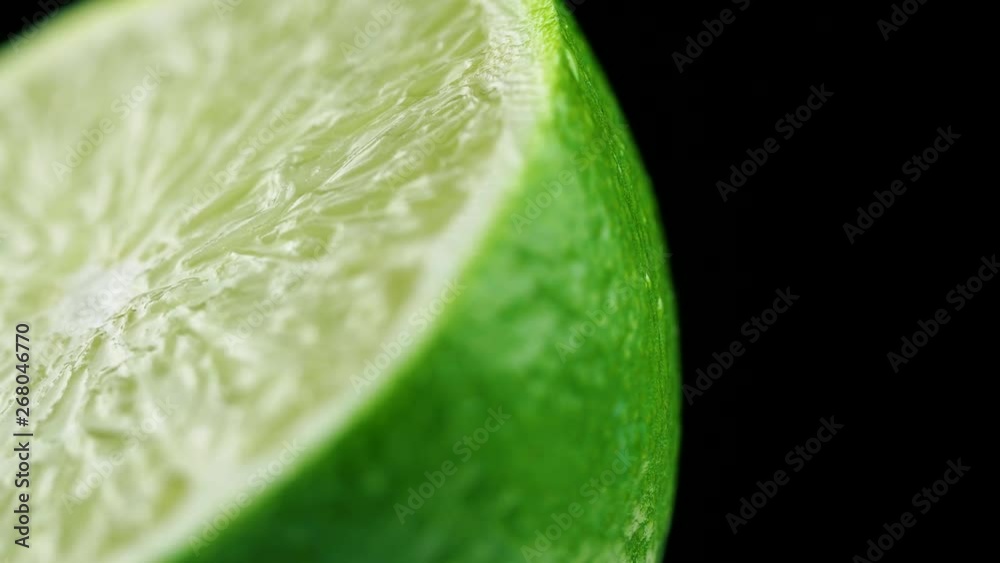 Macro shot of fresh green lime rotating on dark surface. 4K close up footage. Macro shot of fresh green lime rotating on dark surface. 4K close up footage.