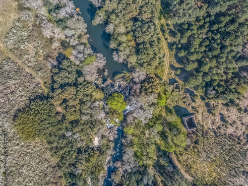 Aerial view of drone, natural landscape river with and colored trees on the banks © Miguel Almeida