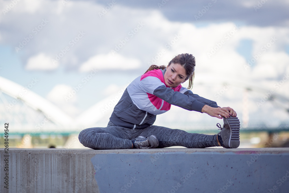 Sport and recreation concept.Active woman stretching legs
