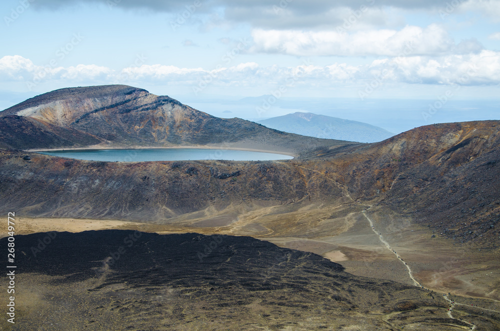 View of Blue lake from Tongariro Alpine Crossing hike with clouds above, North Island, New Zealand