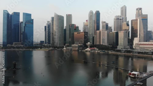 Aerial panoramic view of the financial district in Singapore with drone slowly descending over the bay