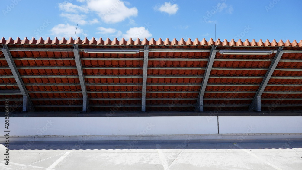 Detail of the eaves of a tile roof. Reinforcement of the underside of the roof overhang with a steel structure on the parking deck of a supermarket in Germany.