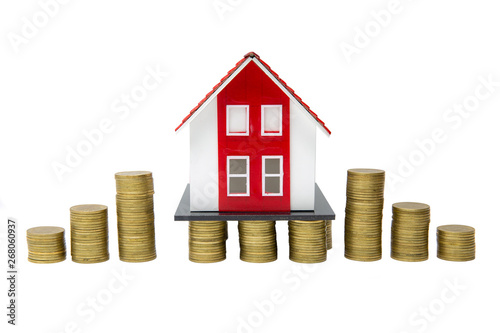 Growth of coins and red houses standing on stacks of coins isolated on white background