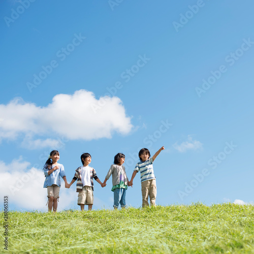 草原で手をつなぐ小学生