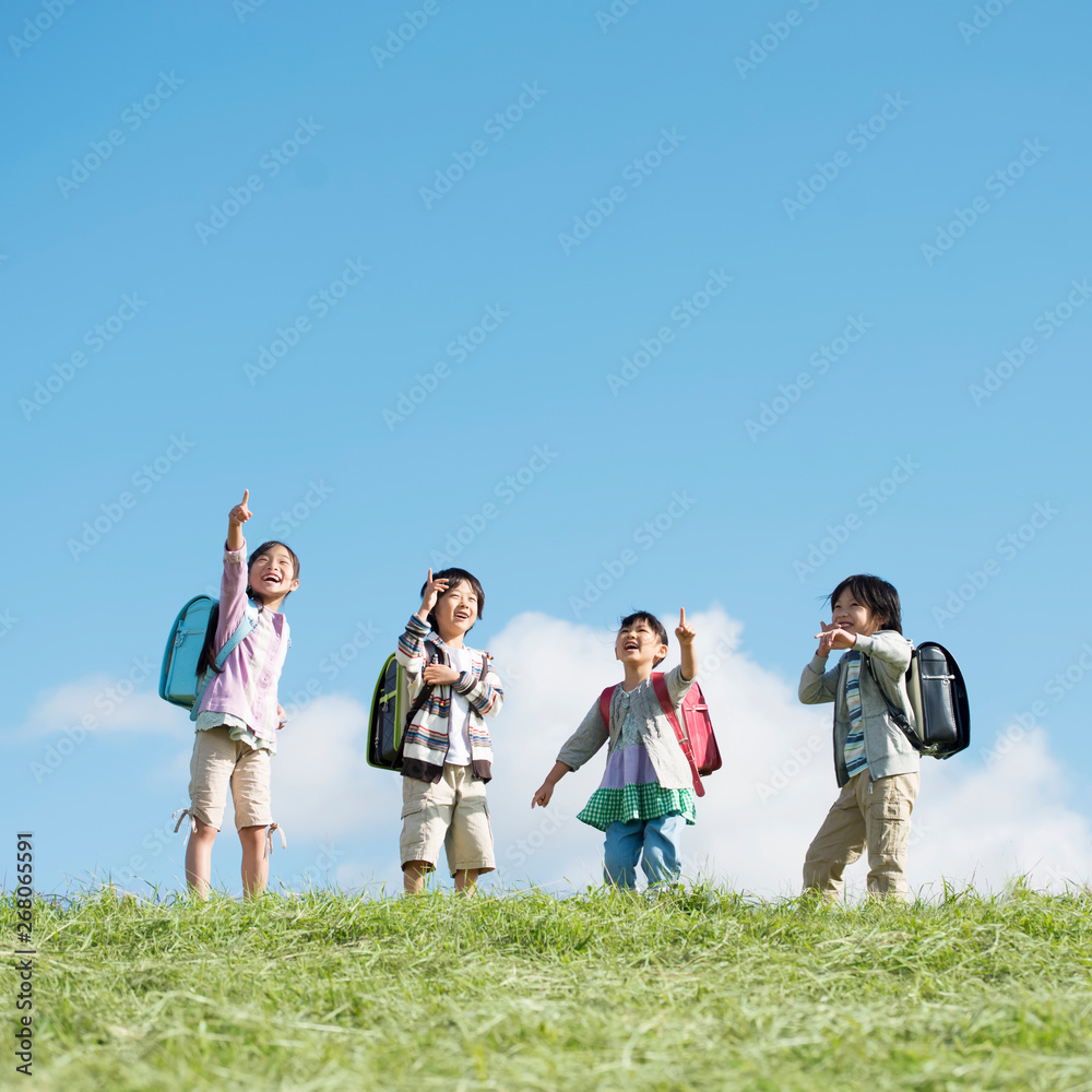 草原で空を見上げる小学生