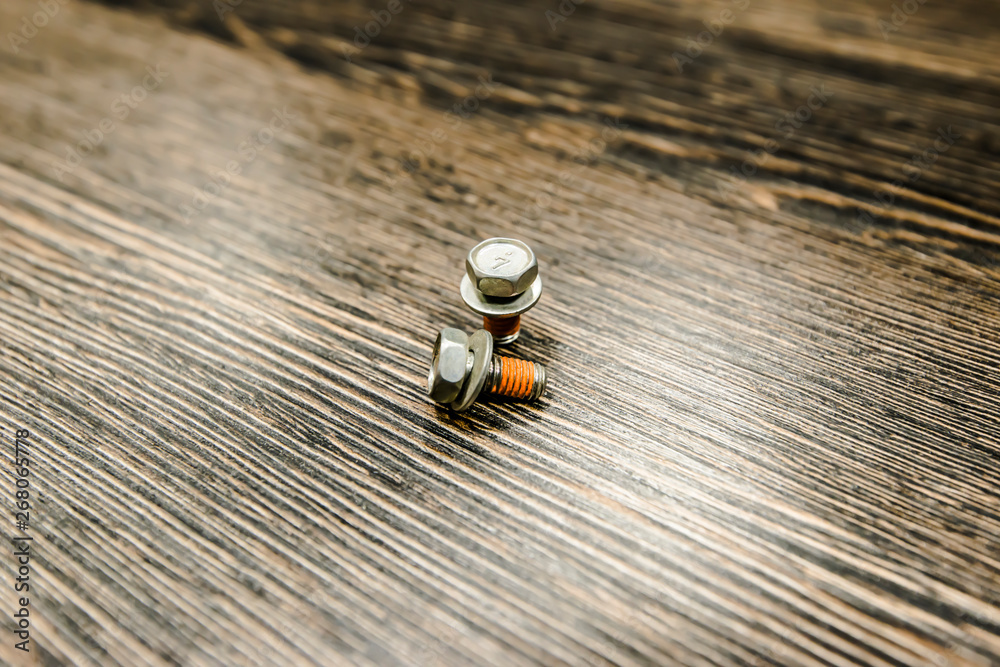 A pair of bolts on wooden background A pair of bolts on wooden background