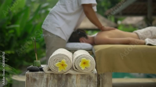 close up rolled towels decorated with yellow flowers and burning incense sticks