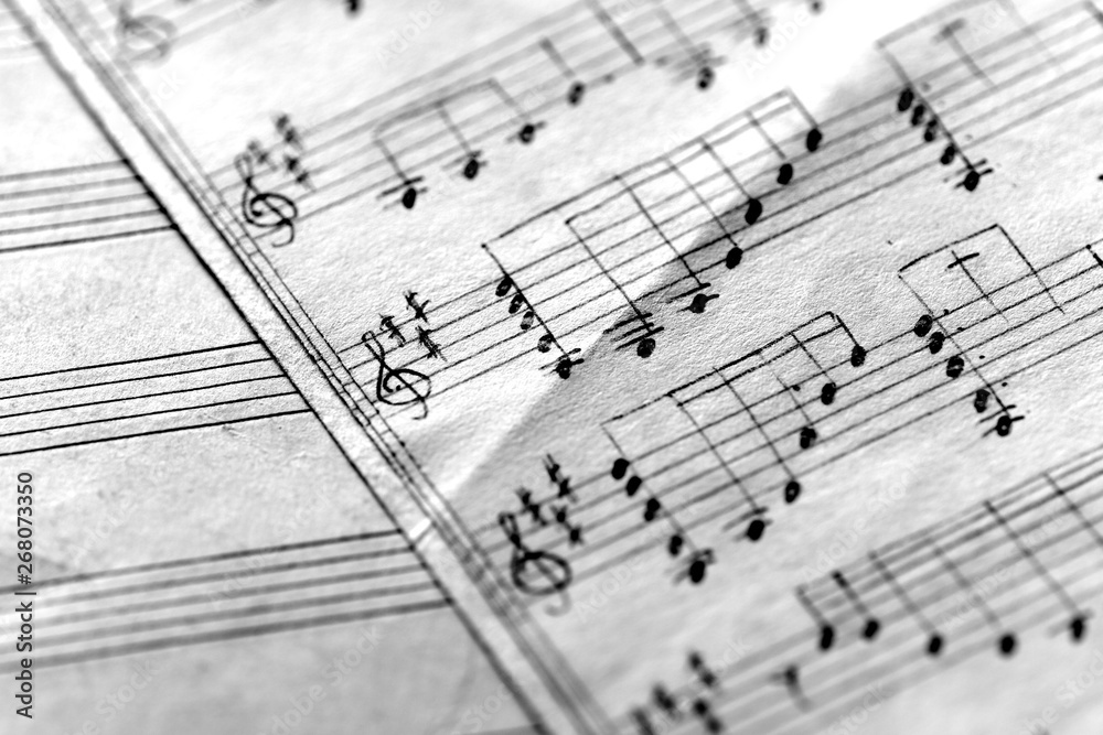 Page of an old musical notebook with hand written notes close up. Black and white