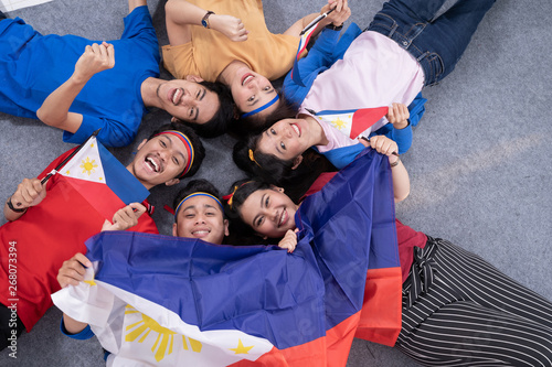 filipino group of people holding philippines flag celebrating independence day photo