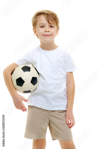 A little boy wearing a pure white t-shirt is playing with a socc © lotosfoto