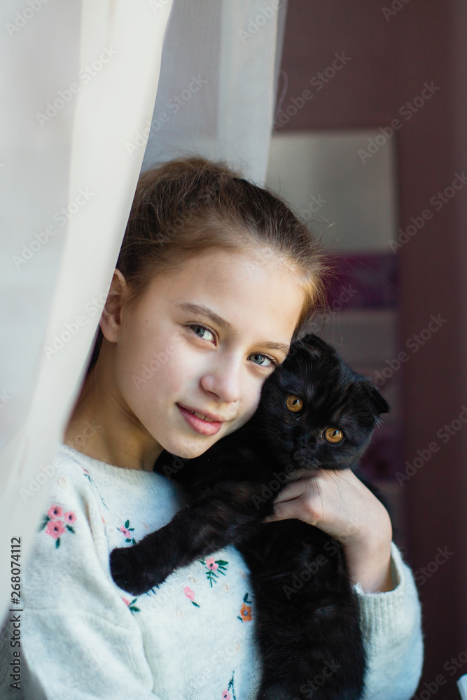 Cute teen girl holding a kitten in her arms. Cute teen girl holding a kitten in her arms.