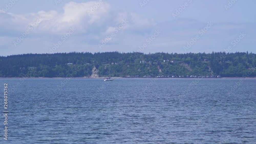Distant sailboat motoring past beach at Camano Island State Park, Washington State 10sec/24fps slow motion. Version 1 Distant sailboat motoring past beach at Camano Island State Park, Washington State 10sec/24fps slow motion. Version 1