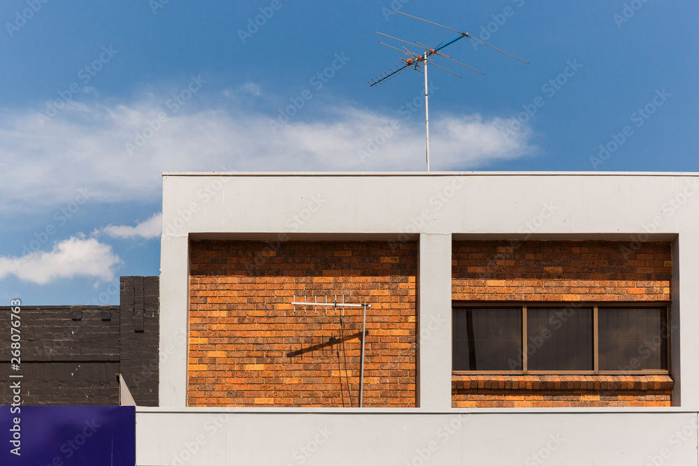 Modern office building with retro analog tv antennas attached. Modern office building with retro analog tv antennas attached.