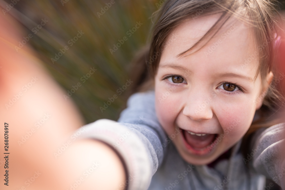 Playful kid holding camera lens towards herself Playful kid holding camera lens towards herself
