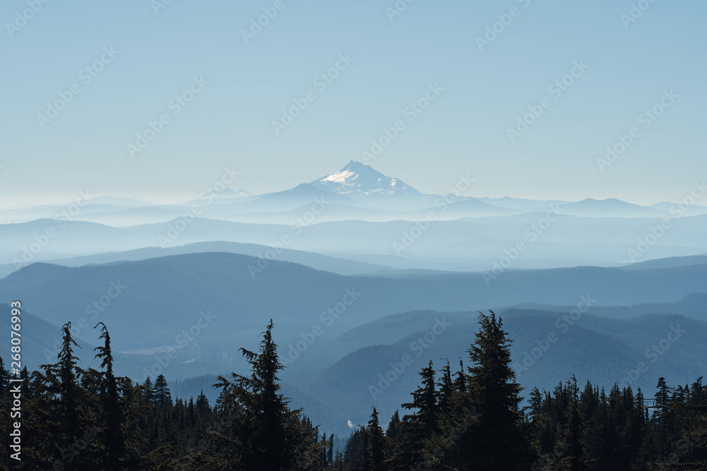 Mount Jefferson and Three Sisters seen from Mount Hood with blue misty silhouettes of mountains.