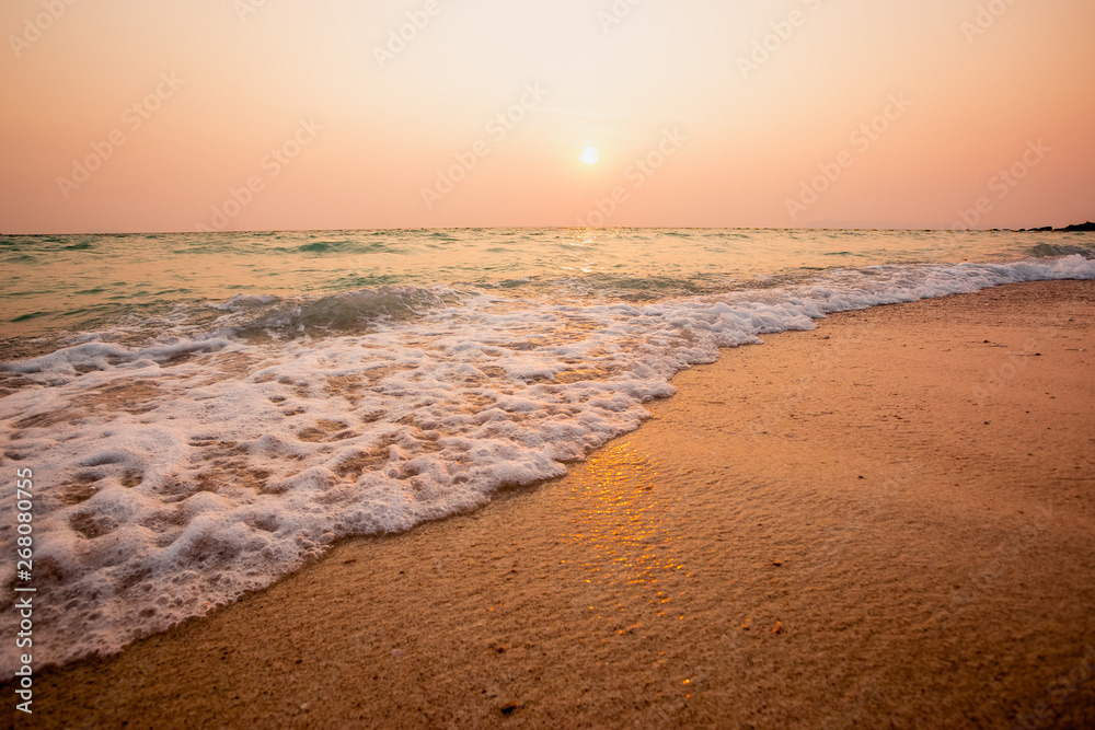 Wave of blue ocean on sandy beach,in sunset. summer background for travel and relaxation in holiday
