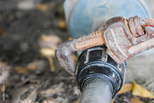 Fototapeta Naklejka Na Ścianę i Meble -  spanner holding water pipe, connected to water impeller