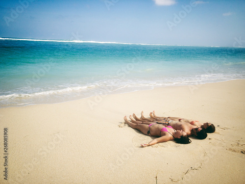 Friends enjoying on a sandy tropical ocean / sea beach. © astrosystem